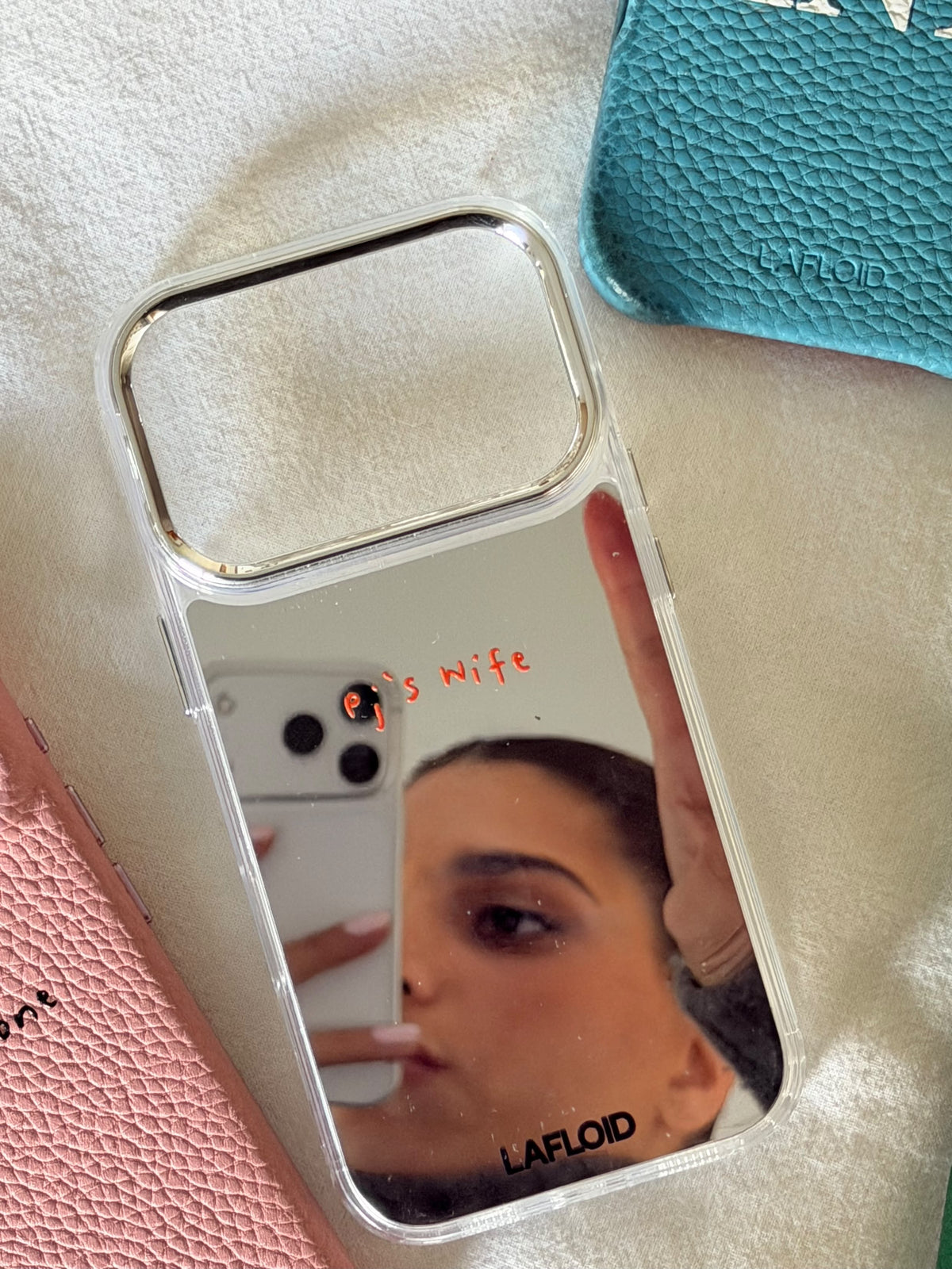 Funda espejo LAFLOID sobre cama junto a otras fundas de colores, lifestyle