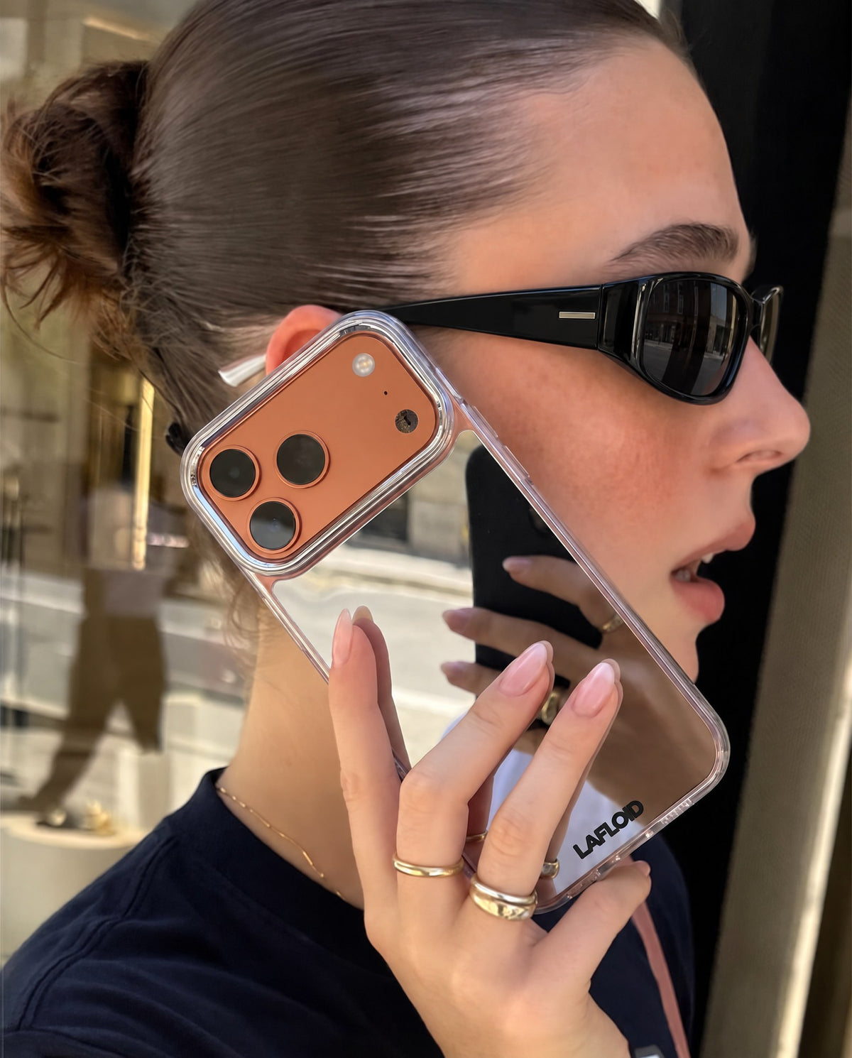 Chica con la funda espejo LAFLOID personalizada en la mano